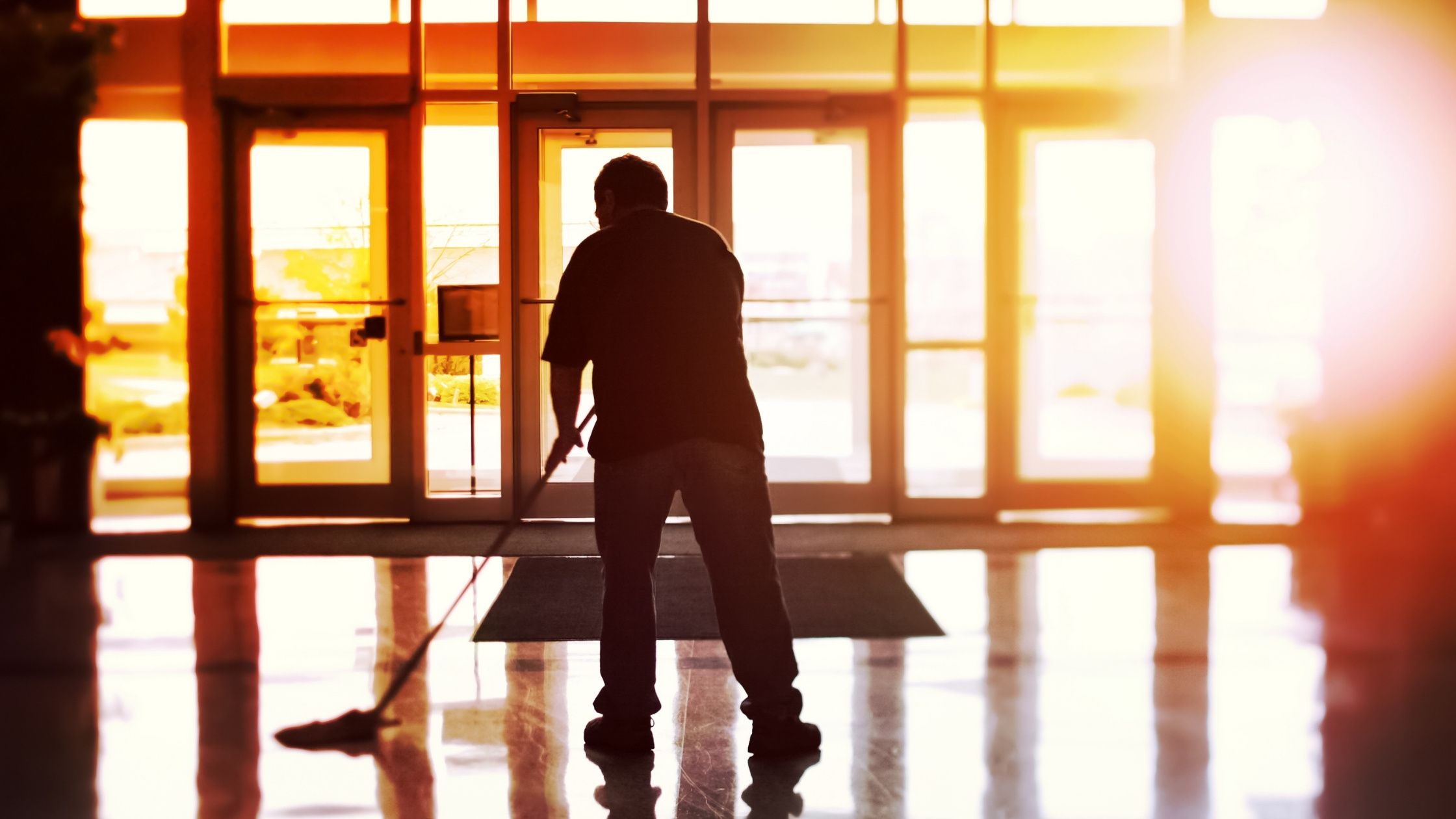 janitor cleaning floor by front doors